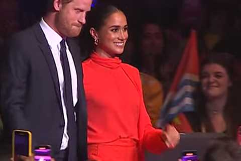 Meghan Markle beams as she takes to stage with Prince Harry and joins Bob Geldof ahead of speech