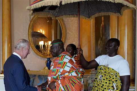 King Charles greets his Ghanaian counterpart The Ashanti King — who shelters under a parasol in..